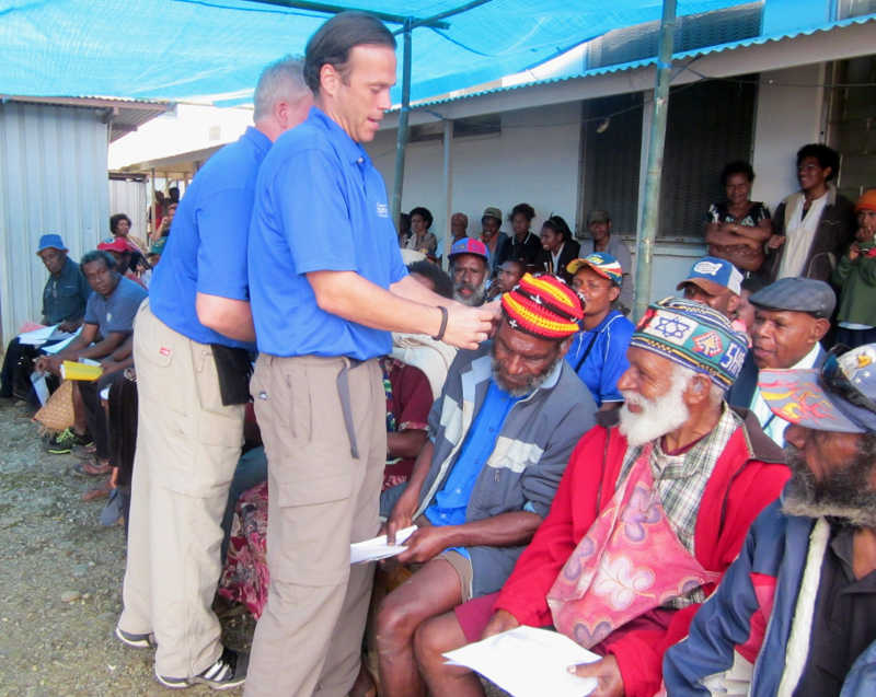 Hearing aid being inserted in a mans ear