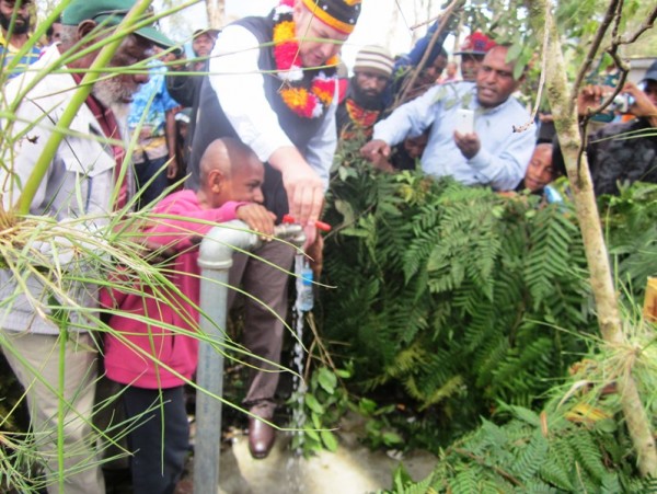 DFAT's James Hall officially turns on the water supply