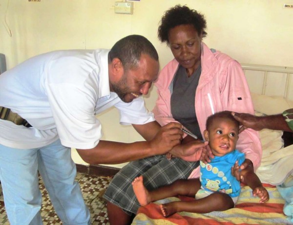 Dr. Richard Kulau of Mendi Hospital checking patient Daniel Hambru from Goroka before he was operated on to correct his upper lips.
