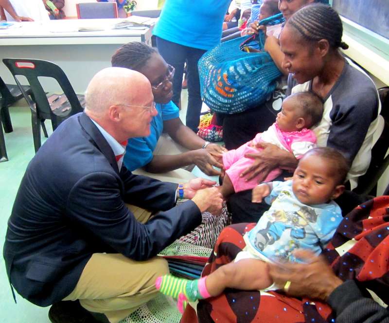 Mr. Daniel Toole chats with a mother and child at the Mt Hagen Urban Maternal and Child Health Clinic.