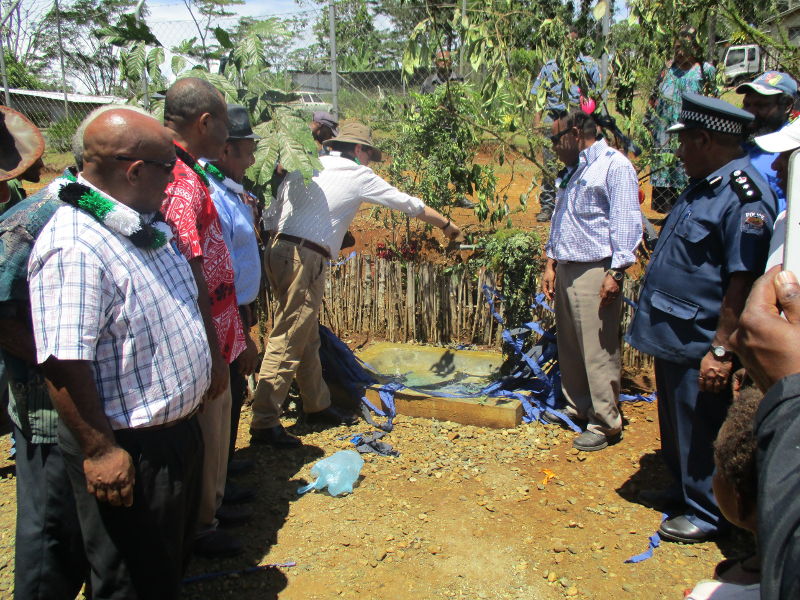 Officials including the Member for Mul/Baiyer/Lumusa, Hon Koi Trape (third on the left with black hat) and Australian High Commissioner, Mr. Bruce Davies (next to Mr. Trape) clapping their hands as the tap is turned on.