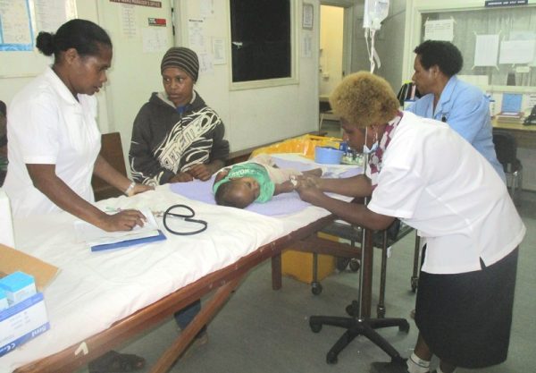 Nurses attending to a baby patient in the Children’s Out-patient Department at Mt Hagen Hospital after returning to work.
