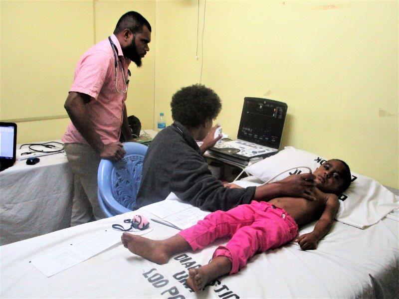 Dr Cornelia Kilalang checks a child’s heart as a medical registrar watches closely.