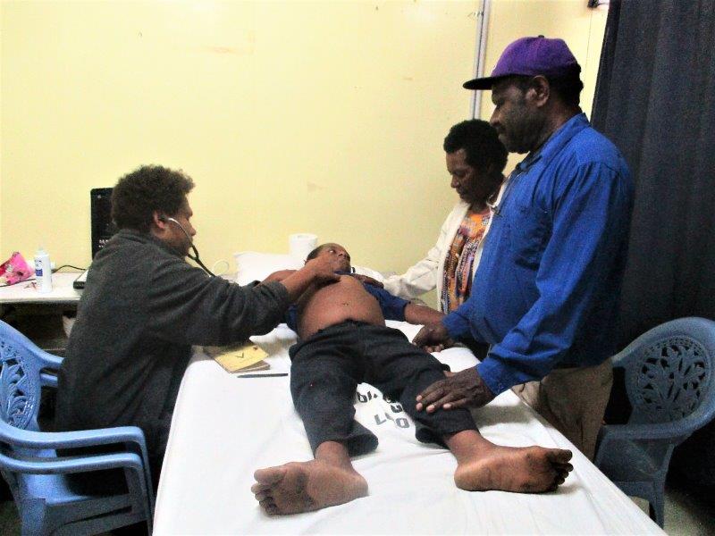 Dr Kilalang examines another child as his mother and Nursing Officer, John Umba comfort him.