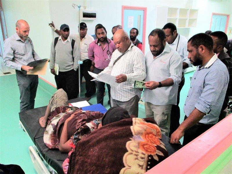 Dr Colin Banks (left) examines a patient’s X-ray while other doctors and health extension officers check her medical history to determine her treatment.