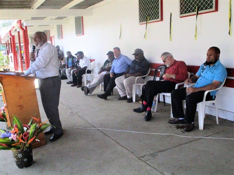 Mr Michael Pundia addressing the audience with invited guests seated.