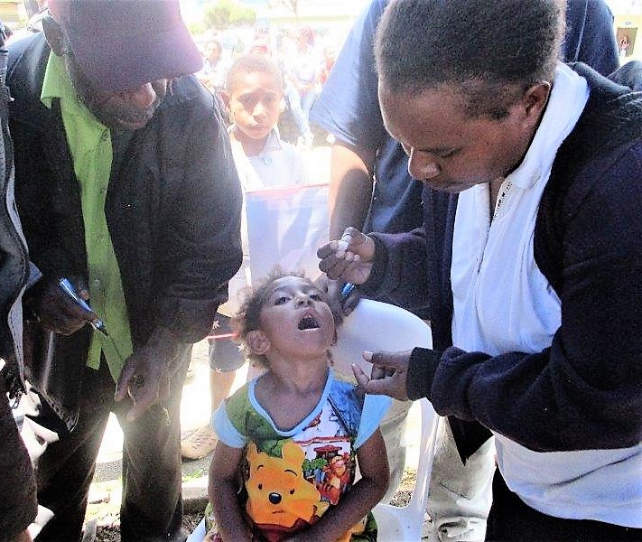 Three-year-old Carmela Koipa about to receive her dose.