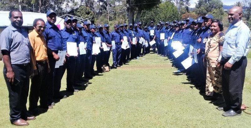 The security guards proudly displaying their new uniforms, joined by some members of the management team for a group picture.