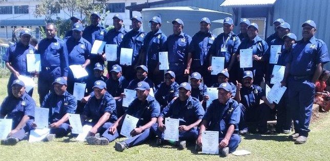 The guards in their new uniforms displaying their certificates.