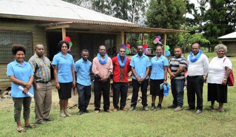 The five students (in blue shirts) and church and WHPHA officials are pictured in front of the out-patients building.