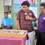 Staff gather to cut a cake to mark the day.