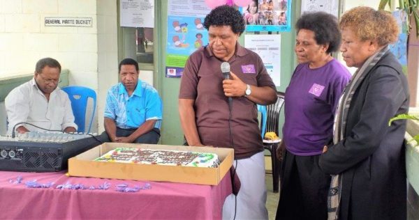 Staff gather to cut a cake to mark the day.