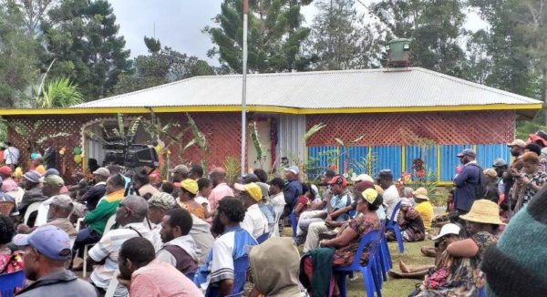 The crowd sitting outside the new family health centre, listening to speeches.