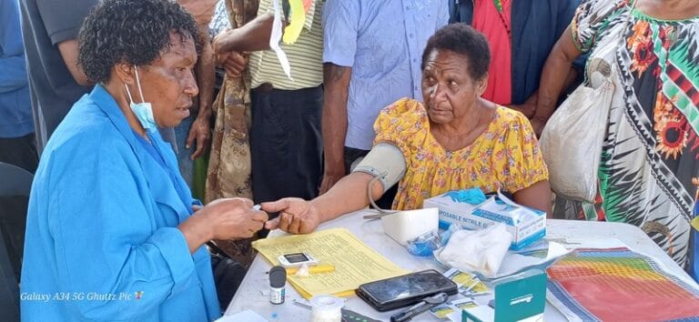 Nurse Dorothy checks the blood and sugar levels of a public attendee, Mamas Kua, who came for a check-up during the awareness program at Pope’s Oval.