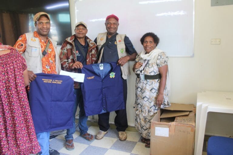 Deputy Director Public Health Freda Pyanyo pose for a picture with x3 male VHAs