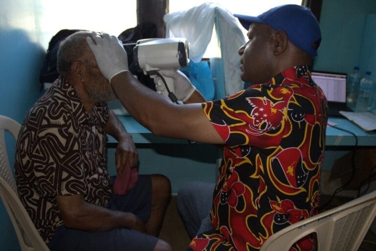 Mr. Sam Rungwa conducts an eye check for a patient