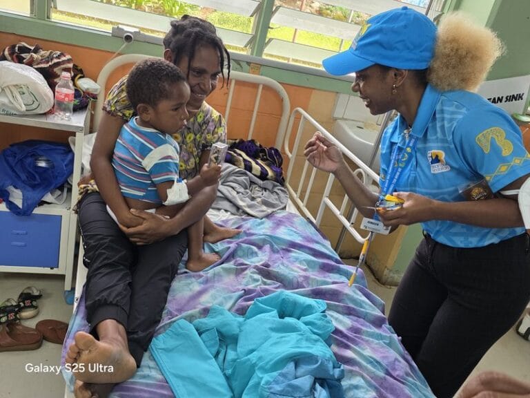 A Brian Bell staff member shares gifts with a child, bringing smiles to the ward.