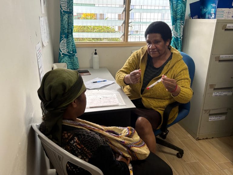 Sr. Robert engages with a woman client at WHPHA’s Cervical Cancer Clinic.